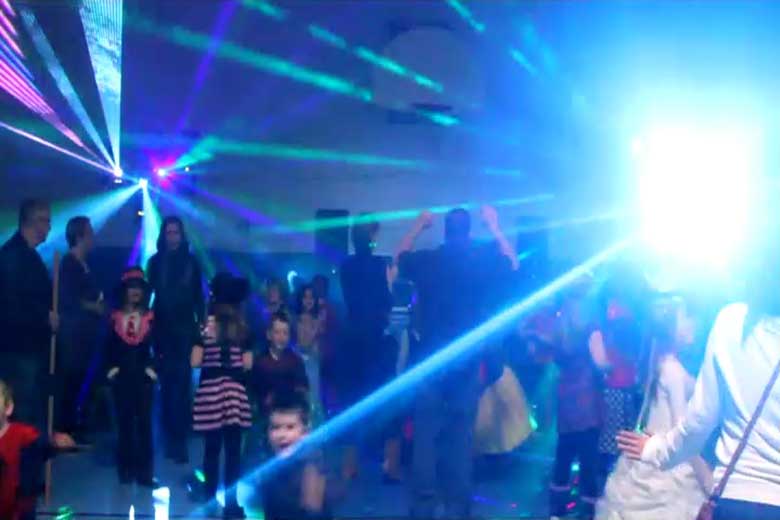 School Light Show, DJ Hamilton, Family Dance, guests dancing with laser beams & special  effects beams  everywhere, Blue beams of light fill the gym with a bit of pink & red on the left. Taken in Hamilton.